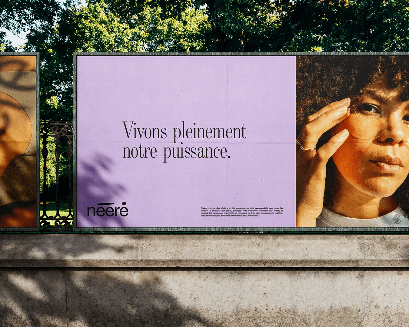 Advertising billboard at the entrance of a city park promoting the Nééré brand, displaying its logo and the slogan “Living our full power,” with visual branding created by Studio La Folie.