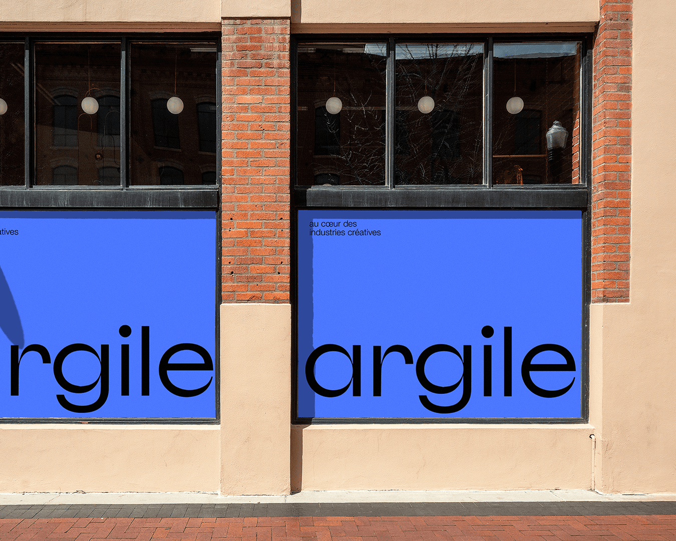 Brooklyn-style ARGILE office storefront on red brick building, main windows fully covered with minimalist blue-lavender graphics, large black logo, visual identity and branding by Studio La Folie.
